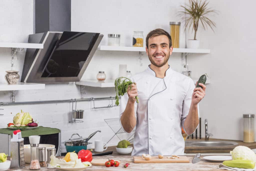 About Us 3 chef kitchen cooking with vegetables